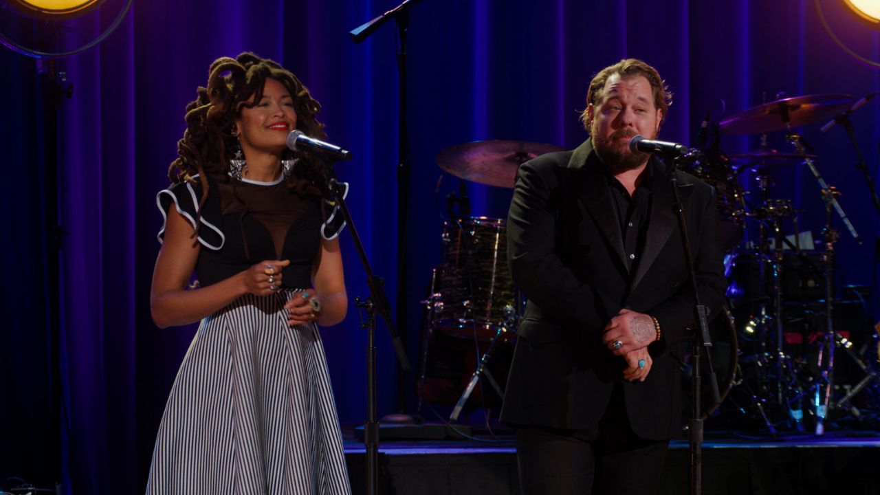 a woman and man singing on stage